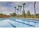 A large swimming pool with blue tile accents and lounge chairs ready for relaxation under palm trees at 1000 Via Canale Dr, Henderson, NV 89011
