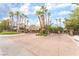 The Summer Trail community entrance features a security gate and lush landscaping with mature palm trees at 10037 Summer Oak Ln # 102, Las Vegas, NV 89134