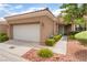 Single-story home showcasing a two-car garage, desert landscaping and a cozy front porch at 10037 Summer Oak Ln # 102, Las Vegas, NV 89134