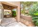 This covered patio features a built-in outdoor kitchen with a stainless steel grill and access to a lush green garden at 10037 Summer Oak Ln # 102, Las Vegas, NV 89134