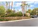 This community area features a parking lot, mailbox station, and lush landscaping with mature palm trees at 10037 Summer Oak Ln # 102, Las Vegas, NV 89134