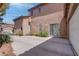 Backyard view, showcasing home's stucco exterior with sliding glass door and two car garage at 10454 Gunpowder Falls St, Las Vegas, NV 89183