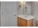 Powder bathroom with a wood cabinet beneath a marble sink, and two white doors at 10454 Gunpowder Falls St, Las Vegas, NV 89183
