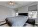 Bedroom with a ceiling fan, natural light, and a striped bedspread and area rug at 10454 Gunpowder Falls St, Las Vegas, NV 89183