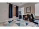 Well-lit bedroom featuring a geometric rug, an arcade game, and dark curtains and cabinets at 10454 Gunpowder Falls St, Las Vegas, NV 89183
