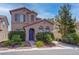 Charming two-story home with desert landscaping, a blue front door, and an attached two car garage at 10454 Gunpowder Falls St, Las Vegas, NV 89183