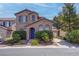 Charming two-story home with desert landscaping, a blue front door, and an attached two car garage at 10454 Gunpowder Falls St, Las Vegas, NV 89183