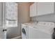 Bright laundry room with modern washer and dryer and white cabinets for storage at 10454 Gunpowder Falls St, Las Vegas, NV 89183