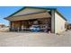 View of Airplane Hangar, concrete floor, with bi-fold door open, airplane inside, and storage shelves at 1100 Mitchell Pl, Pahrump, NV 89060