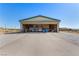 View of Airplane Hangar, concrete floor, with bi-fold door open, airplane inside, and storage shelves at 1100 Mitchell Pl, Pahrump, NV 89060