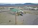 Two-story home with a nice green roof and balcony surrounded by a desert view at 1100 Mitchell Pl, Pahrump, NV 89060