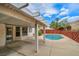 Covered patio area adjacent to a swimming pool in a fenced backyard setting at 114 Tamarack Dr, Henderson, NV 89002
