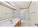 Bathroom featuring white vanity, patterned wallpaper, and bathtub with shower at 114 Tamarack Dr, Henderson, NV 89002