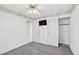 Bedroom featuring neutral carpet, ceiling fan, closet, television and entry to the bathroom at 114 Tamarack Dr, Henderson, NV 89002