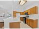 This is a kitchen featuring tile countertops, black and stainless steel appliances and light wood cabinets at 114 Tamarack Dr, Henderson, NV 89002