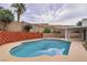 Backyard pool surrounded by lush greenery and brick walls at 114 Tamarack Dr, Henderson, NV 89002