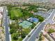 Aerial view of a community park featuring tennis and basketball courts, green spaces, and paved walkways for recreation at 11695 Gentle Birdsong Ave, Las Vegas, NV 89138