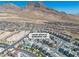 Stunning aerial view of a modern home community nestled against a backdrop of majestic mountains under a clear blue sky at 11695 Gentle Birdsong Ave, Las Vegas, NV 89138