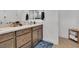 Bathroom with a vanity that has dual sinks and brushed gold hardware at 11695 Gentle Birdsong Ave, Las Vegas, NV 89138