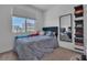 This bedroom has a large window with a soft bed and a full-length mirror at 11695 Gentle Birdsong Ave, Las Vegas, NV 89138