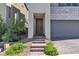 Inviting front entrance with brick stairs, a modern door, and attached garage at 11695 Gentle Birdsong Ave, Las Vegas, NV 89138