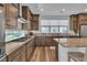 Kitchen with stainless steel appliances, custom range hood, granite countertops and island at 11695 Gentle Birdsong Ave, Las Vegas, NV 89138