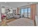 Living room featuring a comfortable gray sofa and sliding glass doors leading to a balcony at 11695 Gentle Birdsong Ave, Las Vegas, NV 89138