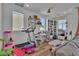 Cozy living room with a gray sectional sofa, a treadmill, and built-in bookshelves at 11695 Gentle Birdsong Ave, Las Vegas, NV 89138