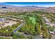 Breathtaking aerial view of a golf course community with lush greenery, residential homes, and mountain backdrop at 11906 Port Labelle Dr, Las Vegas, NV 89141
