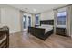 Comfortable bedroom with hardwood floors, a plush bed, and bright windows, creating a relaxing space at 11906 Port Labelle Dr, Las Vegas, NV 89141