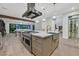 Beautiful kitchen island with seating, stove top, hood, stainless steel sink, and an open concept leading into living area at 11906 Port Labelle Dr, Las Vegas, NV 89141