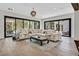 Spacious living room with hardwood floors, large windows, modern furniture, an outdoor view, and a sliding glass door to patio at 11906 Port Labelle Dr, Las Vegas, NV 89141