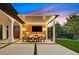 Outdoor kitchen and dining area with built-in grill, TV, covered pergola, and manicured lawn at 11906 Port Labelle Dr, Las Vegas, NV 89141