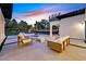 Inviting backyard patio with modern furniture, outdoor fireplace, and lush landscaping against a colorful sky at 11906 Port Labelle Dr, Las Vegas, NV 89141