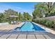 An inviting backyard pool features a modern design, lush landscaping, and a serene water feature at 11906 Port Labelle Dr, Las Vegas, NV 89141