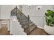 Stylish staircase features wood steps, iron railing, decorative wall paneling, and modern lighting at 11906 Port Labelle Dr, Las Vegas, NV 89141