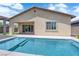 Home's backyard featuring an in-ground swimming pool and direct access to the house through a sliding glass door at 11909 Pippa Ave, Las Vegas, NV 89138