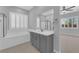 Bright bathroom boasts a soaking tub, glass shower, and vanity with views to bedroom at 11909 Pippa Ave, Las Vegas, NV 89138