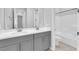 Bright bathroom featuring double sinks with gray cabinets and a shower-tub combo at 11909 Pippa Ave, Las Vegas, NV 89138