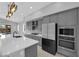 Modern kitchen with stainless appliances, kitchen island, and pendant lights overlooking the yard at 11909 Pippa Ave, Las Vegas, NV 89138