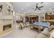Open-concept living room featuring a cozy fireplace, custom built-ins, and large windows at 1329 Calle Cantar, Henderson, NV 89012