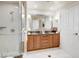 Bathroom featuring a double sink vanity, glass shower with white tile, and a white door at 135 E Harmon Ave # 1703, Las Vegas, NV 89109