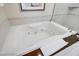 Close-up of a luxurious, bright, and spacious bathtub with jacuzzi jets and a towel at 135 E Harmon Ave # 1703, Las Vegas, NV 89109