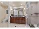 Bathroom featuring double sinks, granite counters, wood cabinets, and a separate glass enclosed shower at 135 E Harmon Ave # 407, Las Vegas, NV 89109