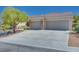 Single-story home featuring a landscaped front yard, stone accents, large driveway, and a 3-car garage at 1744 Williamsport St, Henderson, NV 89052