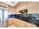 Bright kitchen features wood cabinets, black granite countertops, and stainless steel refrigerator at 1744 Williamsport St, Henderson, NV 89052
