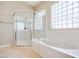 Bathroom featuring a separate shower, soaking tub, and decorative glass block windows at 1744 Williamsport St, Henderson, NV 89052