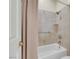 Tiled bathtub and shower with glass door, complemented by neutral walls and fixtures at 2262 Alanhurst Dr, Henderson, NV 89052