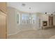 Bright living area featuring a stone fireplace, built-in shelves, tile floors and large windows with shutters at 2262 Alanhurst Dr, Henderson, NV 89052