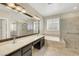Luxurious main bathroom featuring a soaking tub, walk-in glass shower, dual sinks and marble tile at 2262 Alanhurst Dr, Henderson, NV 89052